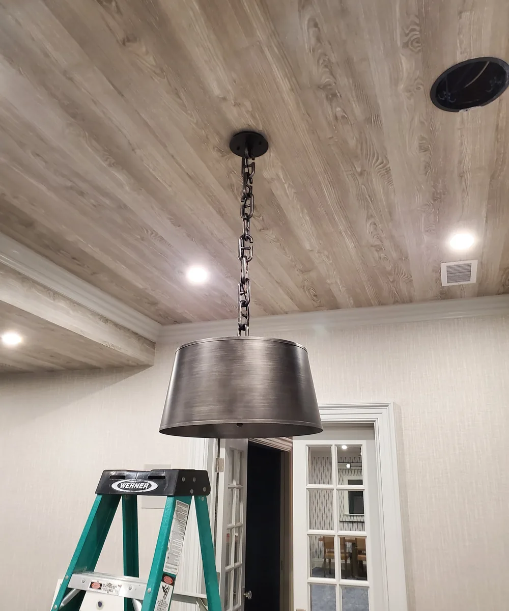 Pendant fixture above a wood ceiling detail